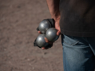 A man prepared to throw the boules ball on a court in outdoor play bocce, petanque