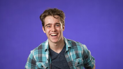 Portrait of laughing smiling happy young hipster man 20s isolated on solid purple background with copy space in studio