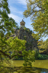 Fototapeta na wymiar Sibyl temple on the hill and lake in Buttes Chaumont Park, Paris, France.