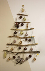 handmade Christmas tree on the wall from branches decorated with shiny balls