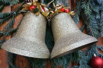 Weihnachtsdekoration mit zwei silbernen Glocken aus Messing, goldenen Schleifen und roten...