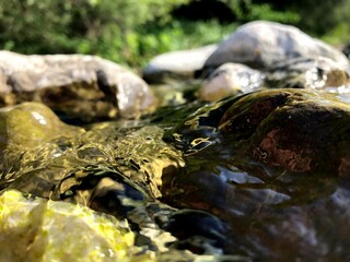 acqua di fiume di montagna che scorre lungo i suoi massi