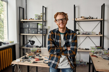 Smiling male IT engineer with crossed arms