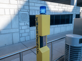 Yellow Emergency  Call tower with a blue light on top at the Ferry Street Q- line station in midtown, Detroit, Michigan