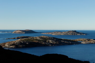 Fototapeta na wymiar Blick über das Meer auf die steinige Küste von Norwegen