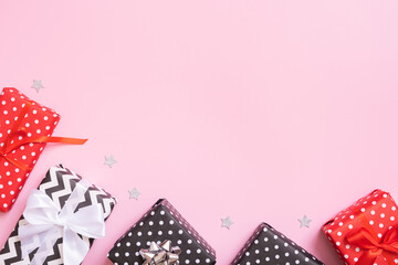 Obraz premium Christmas presents flat lay on a pink background. Top view xmas gifts with decorations