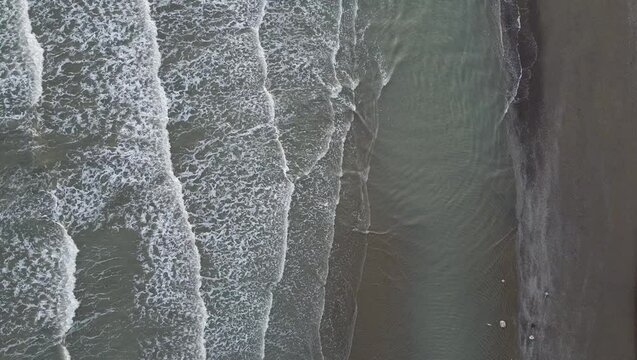 Aerial shot of Eraclea beach with sand, waves and stones, Veneto