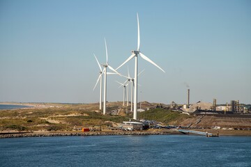 Wind turbines in a coastal area against the blue sky