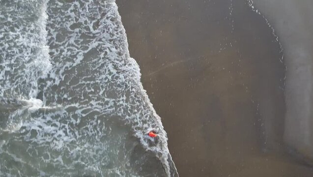Aerial shot of Eraclea beach with sand, waves and stones, Veneto
