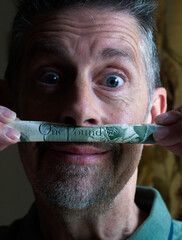 Finance man's money moustache, close up. A playful shot with an old English one pound note. Staring...