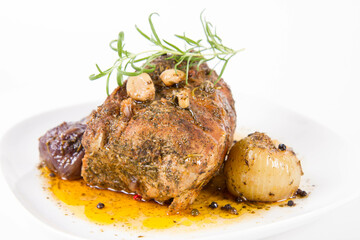 Roast pork loin with onions and garlic, decorated with rosemary and some colorful peppercorns