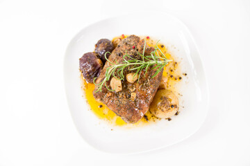 Roast pork loin with onions and garlic, decorated with rosemary and some colorful peppercorns