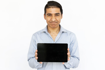 Doubtful man holding tablet. Indian man in blue shirt showing tablet screen expressing suspicion. Portrait, studio shot, technology, advertising concept