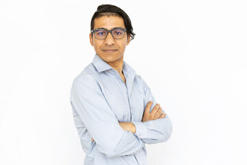 Confident man with arms crossed. Indian man in blue shirt and glasses standing with serious face. Portrait, studio shot, confidence concept