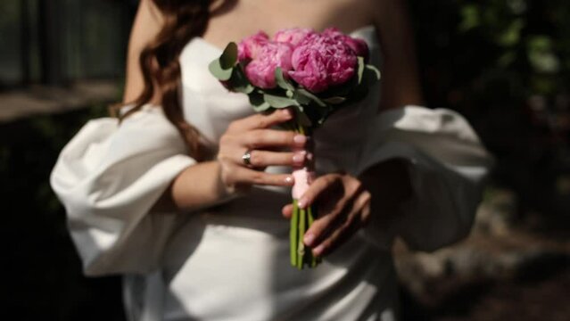 the bride holds a wedding bouquet in her hands