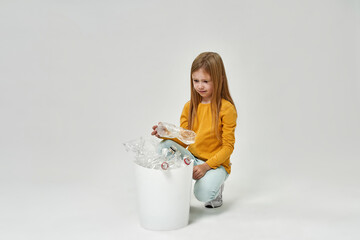 Focused girl look at plastic bottle from full bin