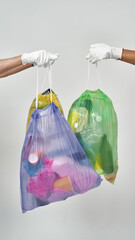 Couple volunteers hands hold sorted garbage bags