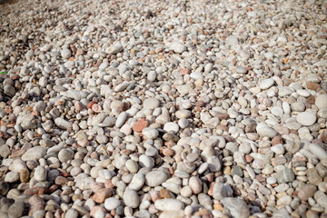 Smooth round pebbles texture background. Pebble sea beach close-up, white, brown and gray dry pebble. Small round stones background.