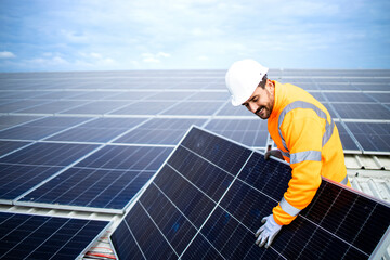 Solar energy worker installing photovoltaic panels on the roof.