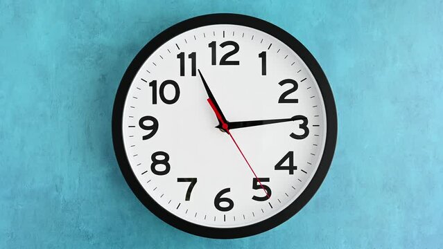 Modern round clock on a blue background, marking time
