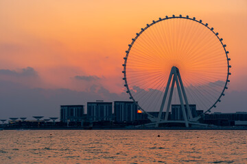 Amazing sunset colors over the sea view to the Ain Dubai, giant Ferris at Bluewaters Island  close to JBR beach. Dubai Eye fits perfect to modern UAE skyline.