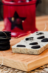 Christmas holiday cookie and chocolate nougat on a wooden table with a pile of cookies and a red...