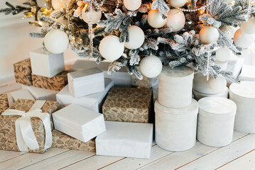 Pile of gift boxes near beautiful Christmas tree indoors