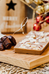 Kinder bar chocolate Christmas nougat with decorations on the background over a wooden table