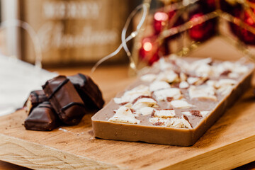 Kinder bar chocolate Christmas nougat with decorations on the background over a wooden table