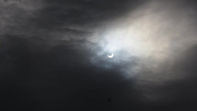 A solar eclipse in cloudy weather through a cloud. partial solar eclipse.