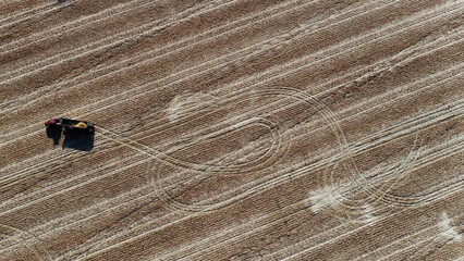 Field from drone. Agricultural photo of autumn harvest. View from a drone. Tractors at work. Harvesting corn. Pattern on the field