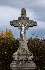 Crucifix on the background of an autumn hedge