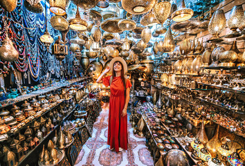 Young traveling woman visiting a copper souvenir handicraft shop in Marrakesh, Morocco - Travel lifestyle concept - obrazy, fototapety, plakaty
