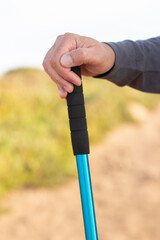 Close-up of male hand with walking pole. Man holding hiking equipment, hobby, leisure, activity concept