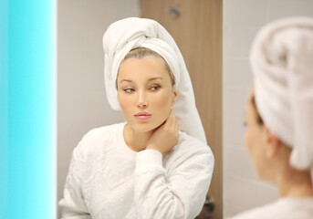 Woman looking in the mirror Applying the cream..Magic anti-aging cream...