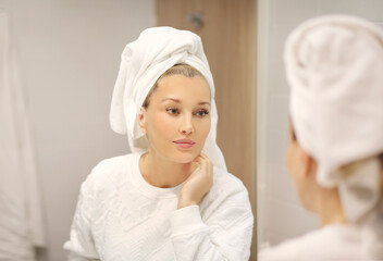 Woman looking in the mirror Applying the cream..Magic anti-aging cream...