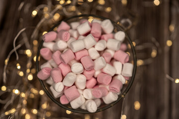 pink and white marshmallows in a cup with fairy lights, Christmas mood, winter dessert