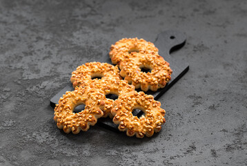 Nut cookies in the shape of a ring, on a serving board. Dark gray background
