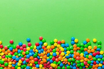 Mixed collection of colorful candy, on colored background. Flat lay, top view. frame of colorful chocolate coated candy