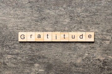 gratitude word written on wood block. gratitude text on cement table for your desing, concept