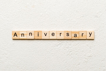 anniversary word written on wood block. anniversary text on cement table for your desing, concept