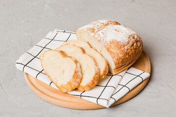 Assortment of freshly sliced baked bread with napkin on rustic table top view. Healthy unleavened bread. French bread slice