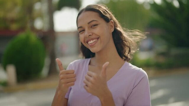 Young african american woman smiling confident doing ok sign with thumbs up at street