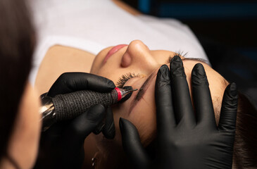 Beauty master applying permanent brow makeup at beauty salon - obrazy, fototapety, plakaty