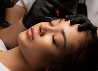 Beauty master making permanent makeup with a machine