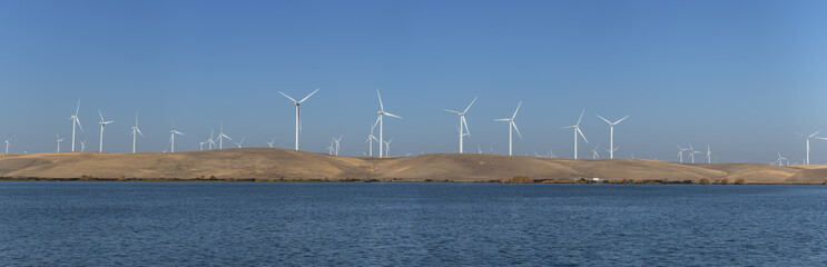 Wind turbines renewable energy off the water in Rio Vista Ca. on a clear day      