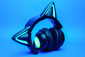 Black wireless headphones are highlighted on a blue background. Cosplay accessory. Wireless gaming...