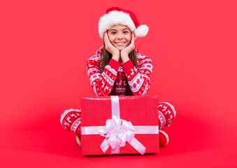 merry christmas. cheerful santa teen girl with christmas present sit in studio. teen girl