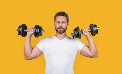 Fototapeta na wymiar fit muscular fitness guy with barbell. muscular fitness guy training with barbell isolated on yellow.
