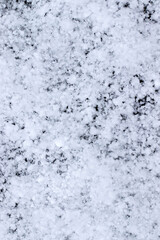 Snow grains and snowflakes are sprinkled on a black background. Freshly fallen snow, winter day